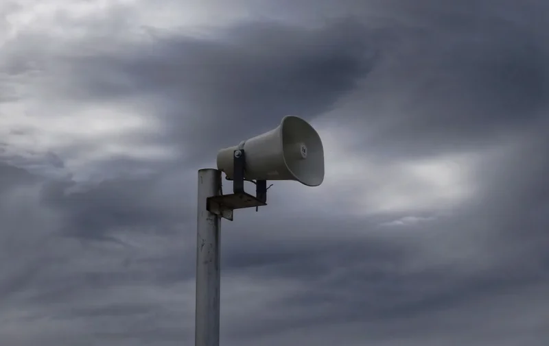 Tornado Siren Against Stormy Sky